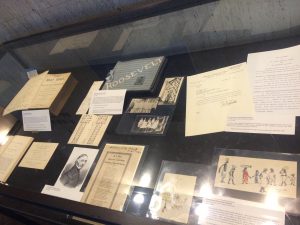 A view of one of the display cases showing the Roosevelt nursing scrapbook in the middle.