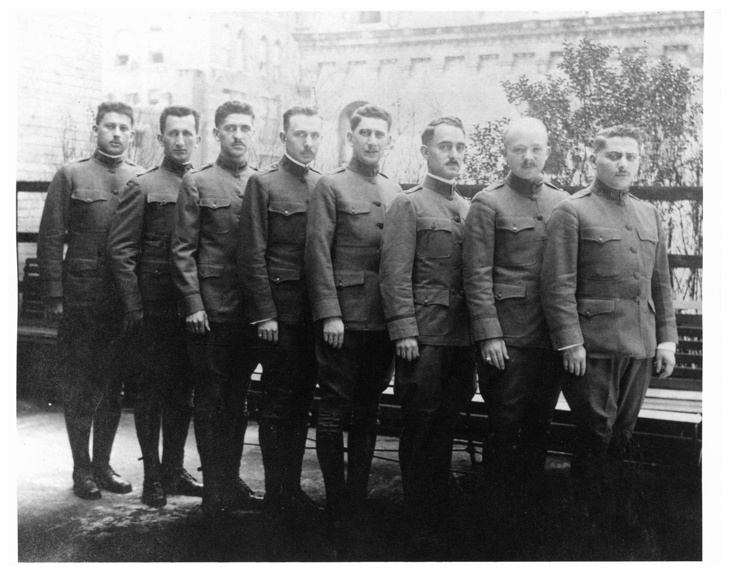 Black and white photograph of eight Beth Israel doctors in World War I uniforms standing in a row, posing on top of the Jefferson and Cherry Street building.