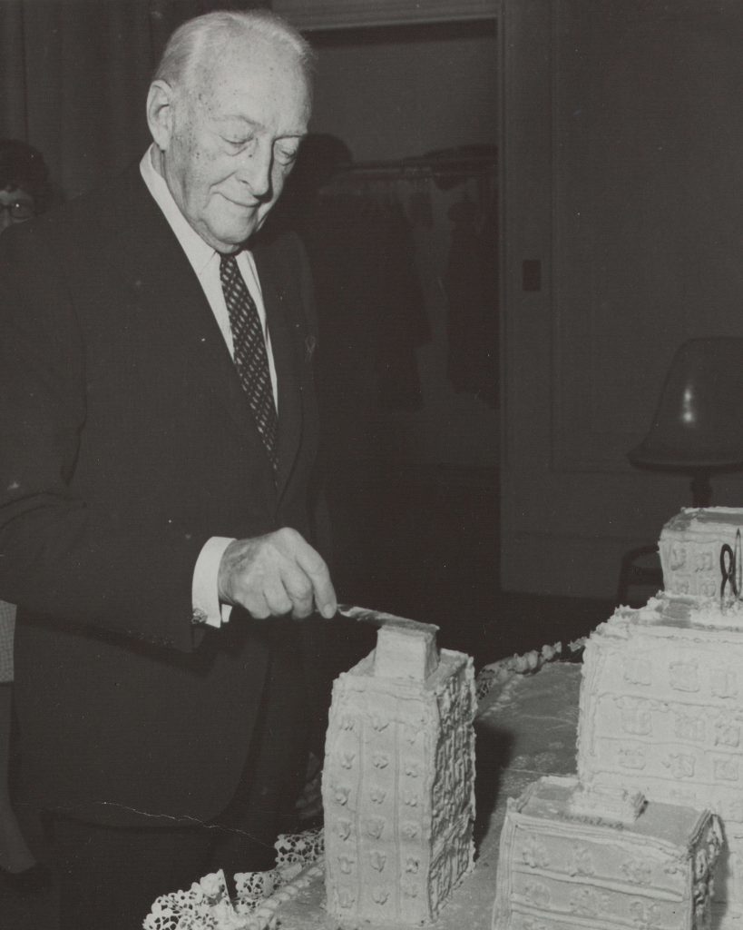 Charles Silver cutting into cake shaped as Beth Israel Hospital